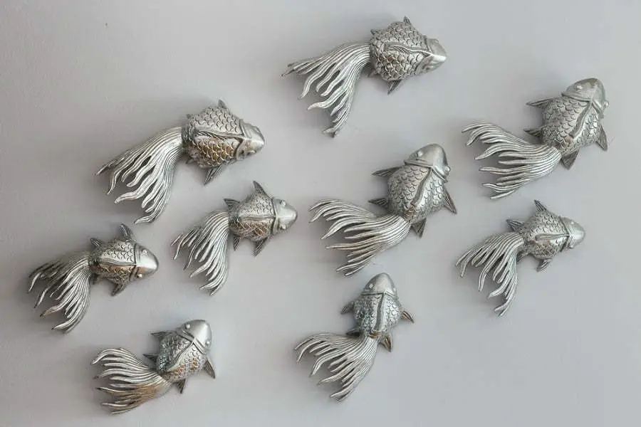 sculpture of metal fish hang on the wall